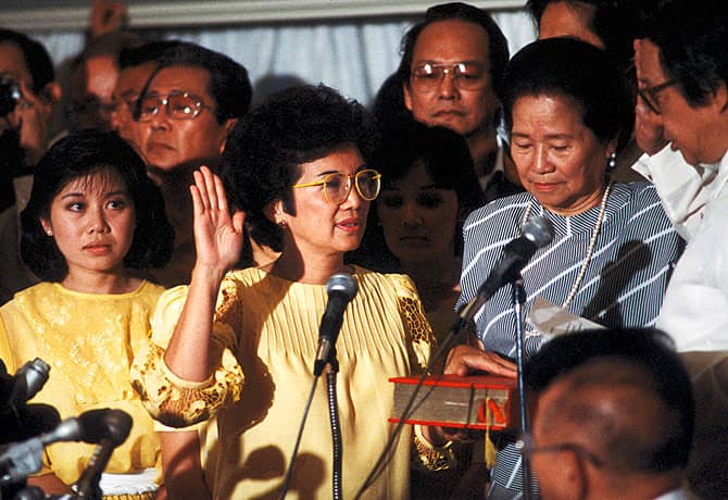 Corazon Aquino raises her right hand as she takes the oath of office on February 25, 1986